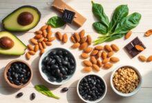 Benefits of magnesium shown through an array of magnesium-rich whole foods on a wooden surface.
