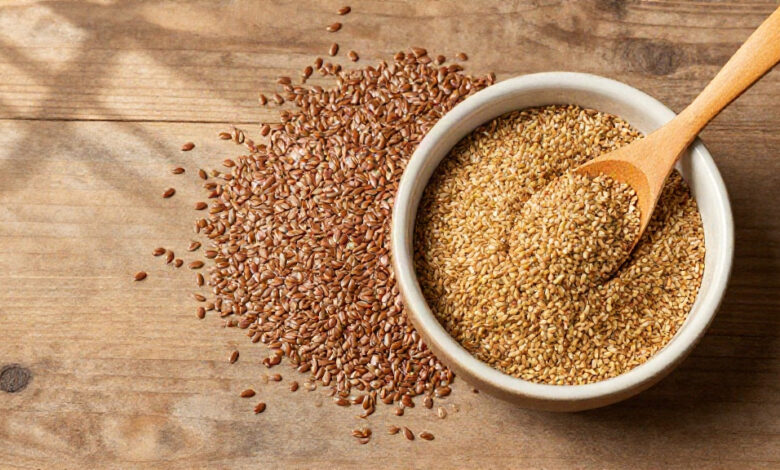 Flax seeds in whole and ground form displayed on a rustic wooden table surface.